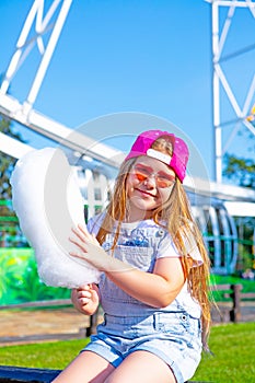 Happy little girl eating cotton candy