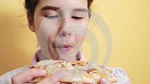 Happy little girl eating a slice of pizza concept. lifestyle teenager child hungry eats a slice of pizza. slow motion