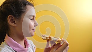 Happy little girl eating a slice of pizza concept. Teenager child hungry eats a lifestyle slice of pizza. Slow motion