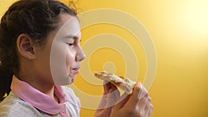 Happy little girl eating a slice of pizza concept. teenager child hungry eats a slice of lifestyle pizza. slow motion