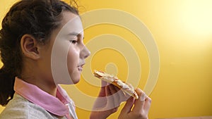 Happy little girl eating a slice of pizza concept. teenager child hungry eats a slice of pizza. lifestyle slow motion