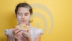 Happy little girl eating a slice of pizza concept. teenager child hungry eats a slice of pizza. slow motion lifestyle