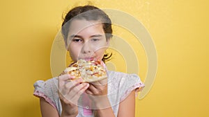 Happy little girl eating a slice of pizza concept. teenager child hungry eats a slice of pizza. slow motion video