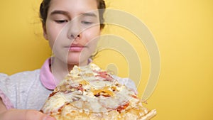 Happy little girl eating a slice of pizza concept. teenager child hungry eats a slice of pizza. slow motion video. pizza