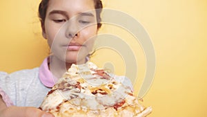 Happy little girl eating a slice of pizza concept. teenager child hungry eats a slice of pizza. slow motion video. pizza