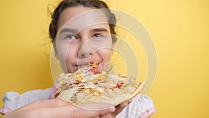 Happy little girl eating a slice of pizza concept. teenager child hungry eats a slice of pizza. slow motion video. pizza
