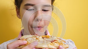 Happy little girl eating a slice of pizza concept. teenager lifestyle child hungry eats a slice of pizza. slow motion