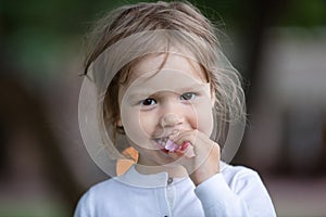 Happy little girl eating sweets outdoors