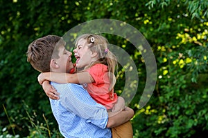 Happy Little Girl Embraces Her Loving Brother, Teenager Boy, Showcasing the Warmth and Love within Their Family Bond