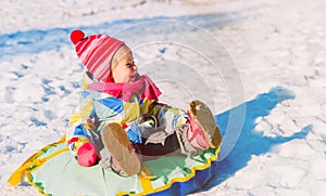 Happy little girl enjoy snow ride, winter kids activities