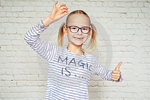 Happy little girl in eyeglasses with lost baby tooth and toothless mouth