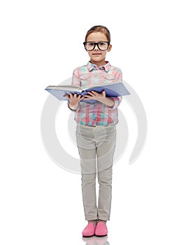 Happy little girl in eyeglasses reading book