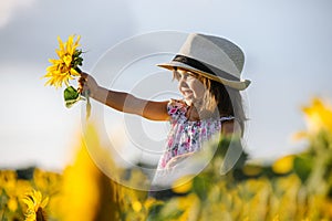 Happy little girl on the field of sunflowers in summer. beautiful little girl in sunflowers