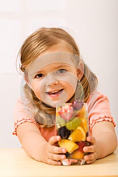 Happy little girl with fruity refreshment photo