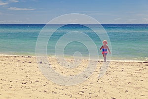 Happy little girl going to swim at beach