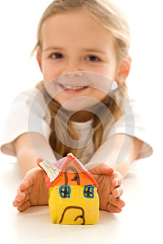 Happy little girl with hand made clay house