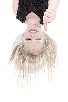 Happy little girl hanging upside down isolated on