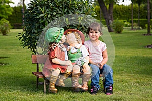 Happy little girl have fun with garden dolls
