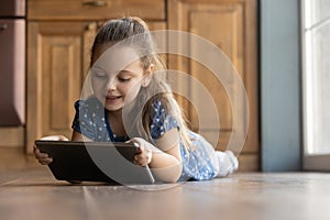 Happy little girl have fun using tablet gadget