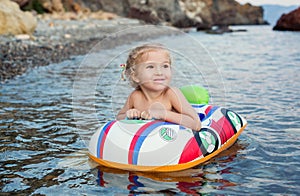 Happy little girl having fun bathing in sea