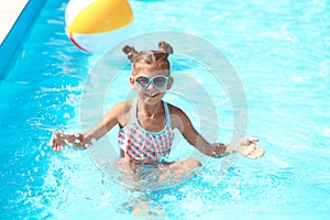 Happy little girl having fun in pool