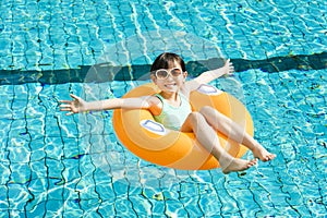 Happy little girl having fun in swimming pool