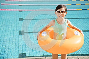 Happy little girl having fun in swimming pool