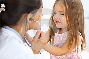 Happy little girl at health exam at doctor office. Medicine and health care concept