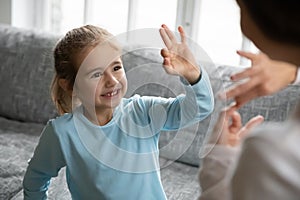 Happy little girl with hearing impairment enjoying communicating with mother.