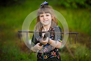 Happy little girl help parents in garden with rake