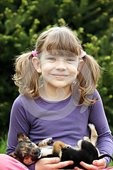 Happy little girl holding cute puppy