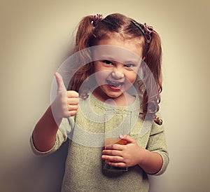 Happy little girl holding glass of juice