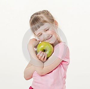 Happy little girl holding a green apple