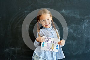Happy Little Girl Holding Greeting Card for Fathers Day
