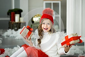 Happy little girl holding a lot of boxes with gifts. winter holidays, christmas and people concept.