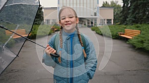 Happy little girl holding umbrella pouring rain looking at sky wet fresh air relax joyful fun favorite weather park