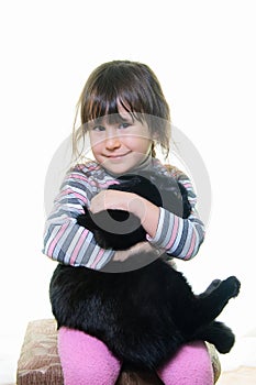 Happy little girl hugging lovely kitten.