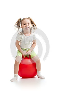 Happy little girl jumping on bouncing ball. Isolated on white.