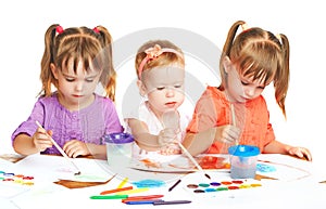 Happy little girl in kindergarten draw paints on white background