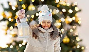 happy little girl with lantern over christmas tree