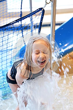 Happy Little Girl Laughs as She Plays in Water at Swimming Pool