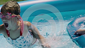 Happy little girl learning how to swim in pool . Father and daughter laughing together - slow motion.