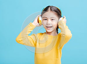 Happy little girl   listens to music in headphones