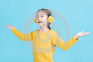 Happy little girl   listens to music in headphones