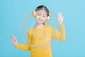 Happy little girl   listens to music in headphones