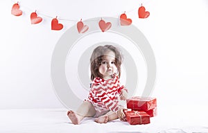 Happy little girl opens a red gift box on a white isolated background