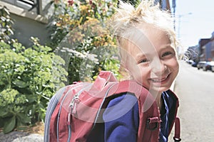 Happy little girl outside with backpack