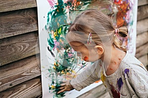 Happy little girl painting with watercolors