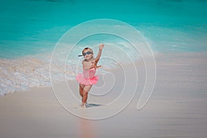 happy little girl play with water on beach, family vacation