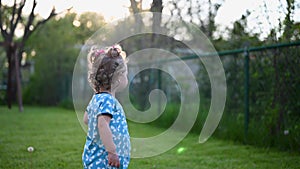 Happy little girl playing in backyard in summer